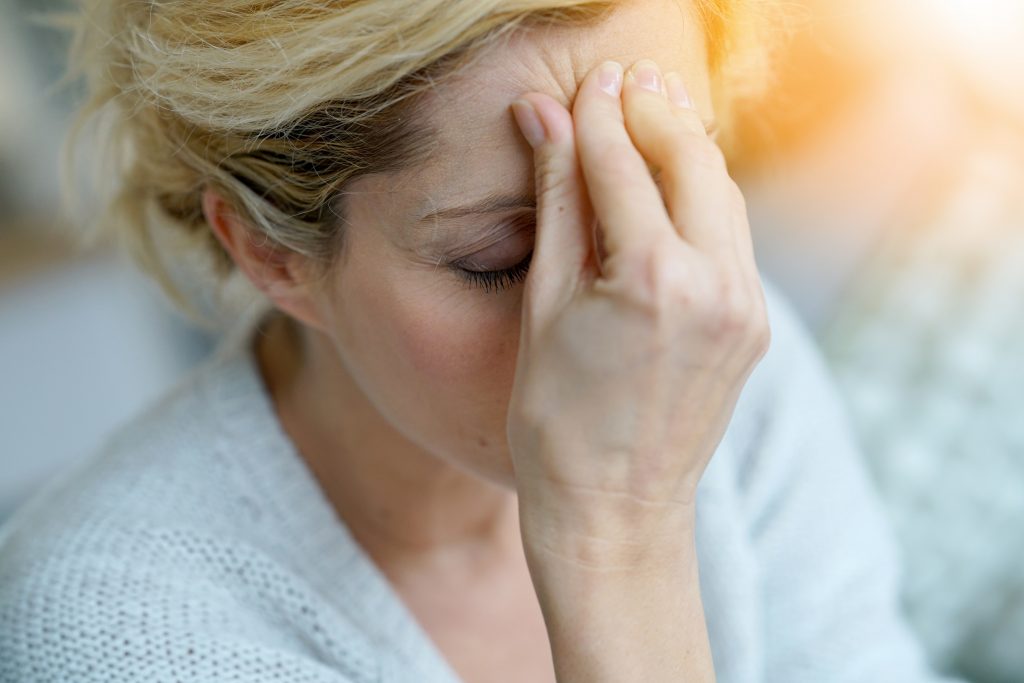 Portraitbild einer Frau mittleren Alters mit einem Migräne-Anfall